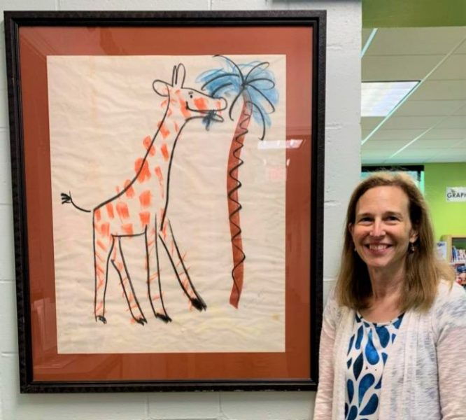 woman standing by painting of giraffe